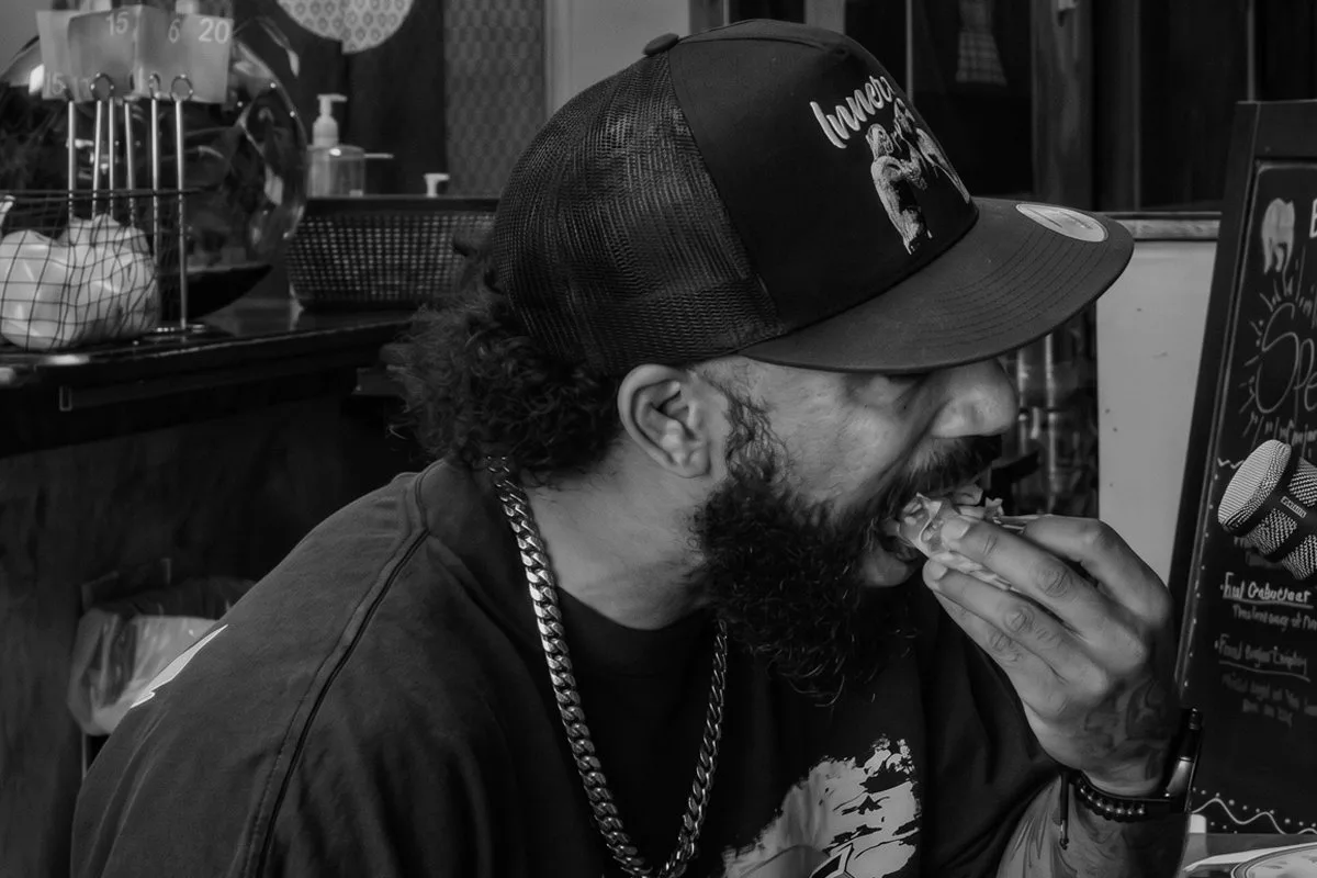A guest takes a bite of food at a local restaurant during a Clinch Chronicles episode