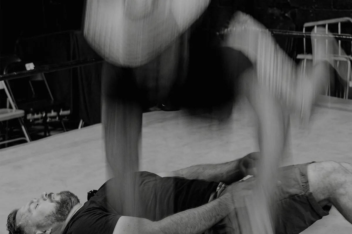 A wrestler comes down on the host lying on the ring canvas during a demonstration